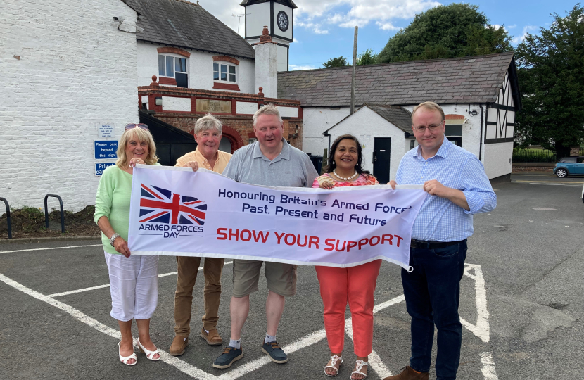 Simon Eardley and four other people holding up a banner that supports the Armed Forces