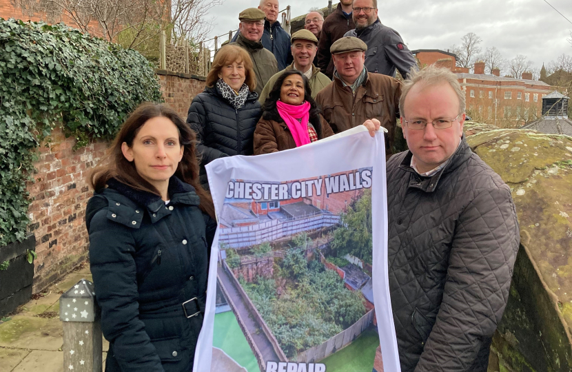 Simon Eardley holding up a banner with other people on Chester's city walls