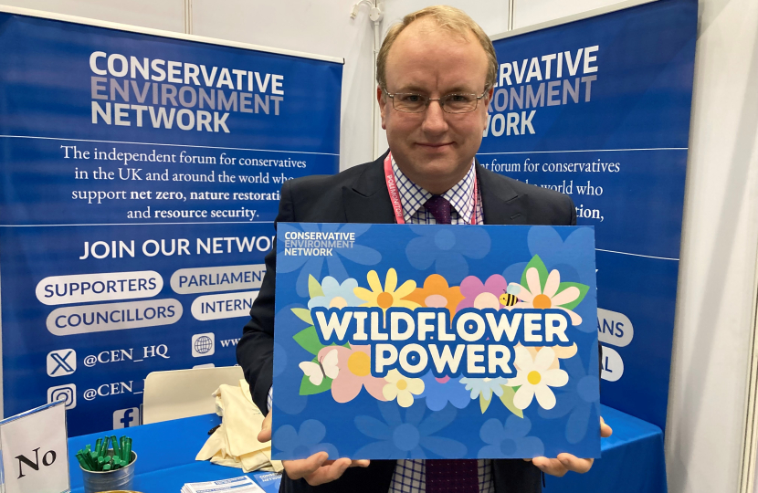 Simon Eardley holding up a poster that says wildflower power