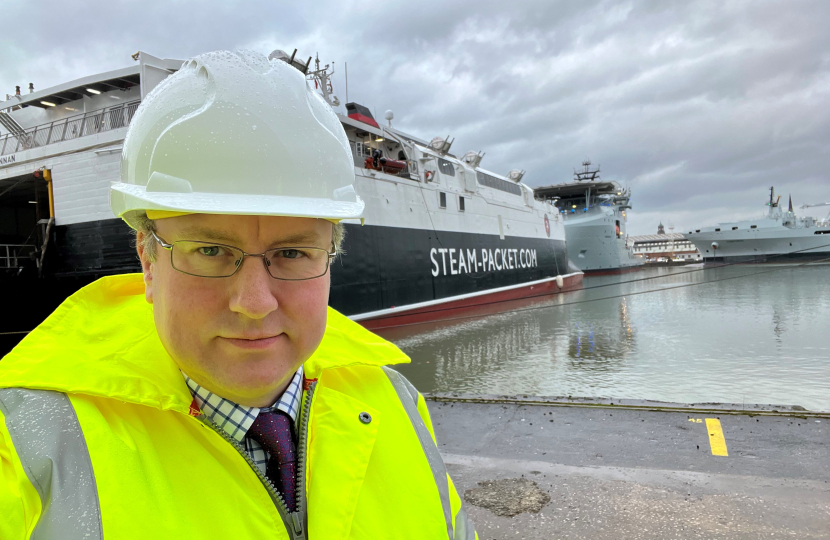 Simon Eardley in a hi viz jacket and hard hat in front of a steamer packet