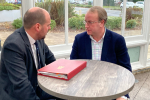 Simon Eardley meeting a minister and sitting at a table